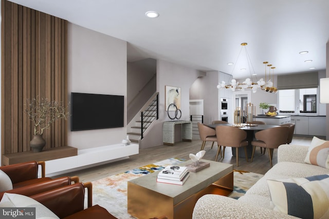 living room featuring recessed lighting, stairway, an inviting chandelier, and wood finished floors