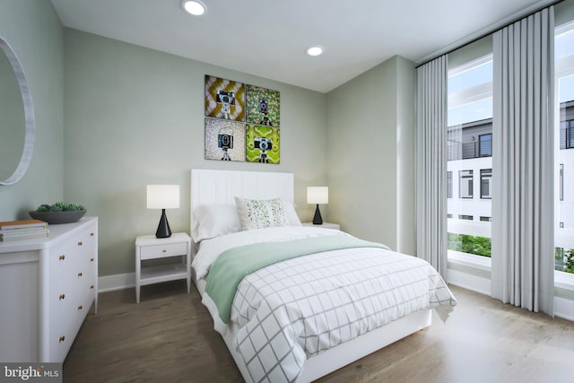 bedroom with wood finished floors, baseboards, and recessed lighting