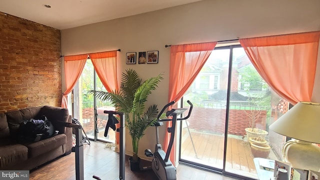 exercise room featuring light hardwood / wood-style flooring and brick wall