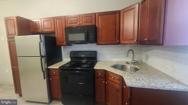 kitchen with black appliances, sink, light stone countertops, and backsplash