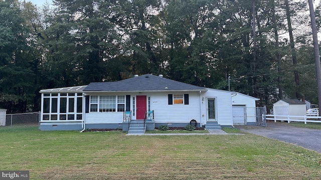 view of front of property featuring a front yard, an outbuilding, and a garage