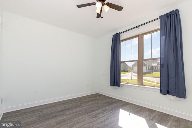 spare room with dark wood-type flooring, plenty of natural light, and ceiling fan