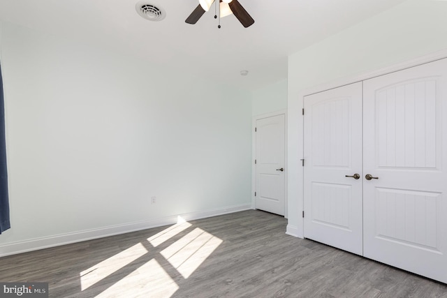 unfurnished bedroom with a closet, light wood-type flooring, and ceiling fan