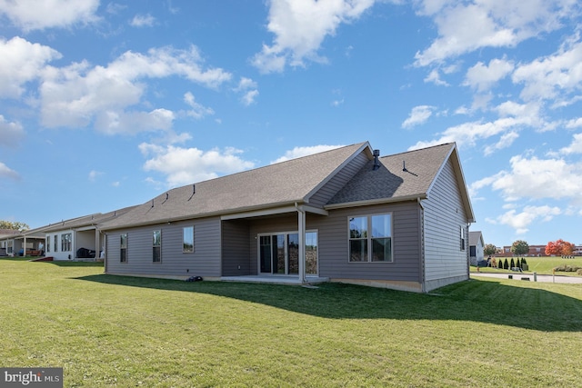 rear view of house with a patio and a lawn