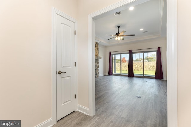 interior space featuring light hardwood / wood-style flooring, a tray ceiling, and crown molding