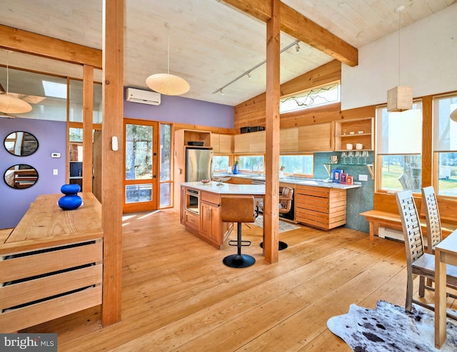 kitchen featuring pendant lighting, light hardwood / wood-style floors, an AC wall unit, and stainless steel appliances