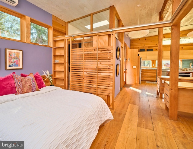 bedroom featuring stainless steel refrigerator, light hardwood / wood-style flooring, and wood ceiling