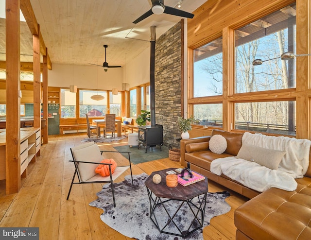 sunroom featuring a wood stove and ceiling fan