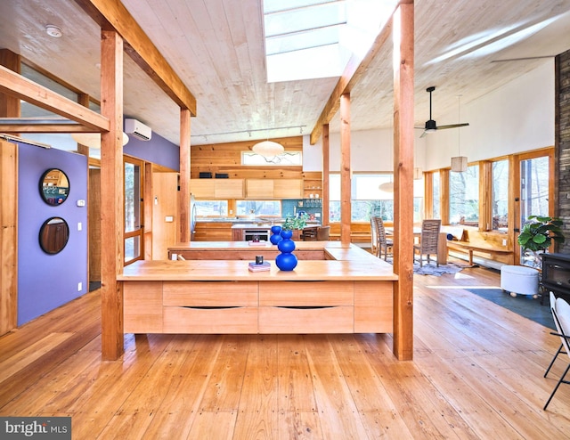 kitchen featuring wood counters, light brown cabinetry, light wood-type flooring, ceiling fan, and beamed ceiling