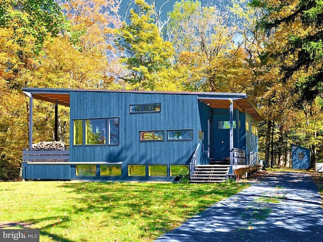 view of front of property with a front lawn and a shed