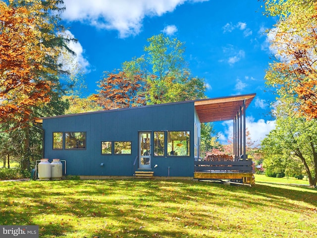 back of property with a yard and a wooden deck