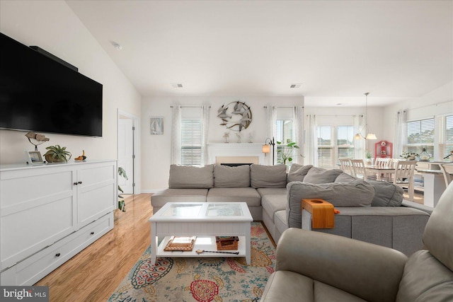 living room featuring light wood-type flooring and vaulted ceiling