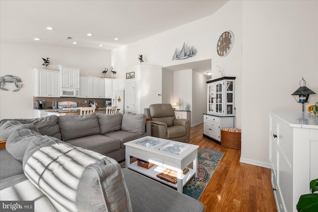 living room featuring hardwood / wood-style floors and high vaulted ceiling