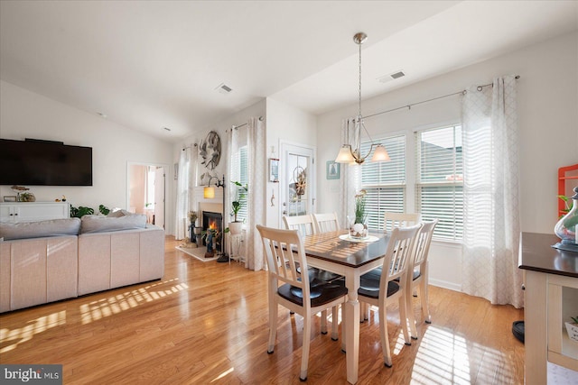 dining room with light wood-type flooring and lofted ceiling