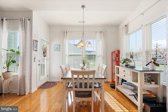 dining area with light wood-type flooring and a healthy amount of sunlight