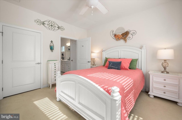 bedroom featuring connected bathroom, light colored carpet, and ceiling fan