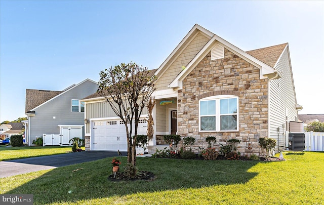 view of front facade featuring central AC unit, a front yard, and a garage