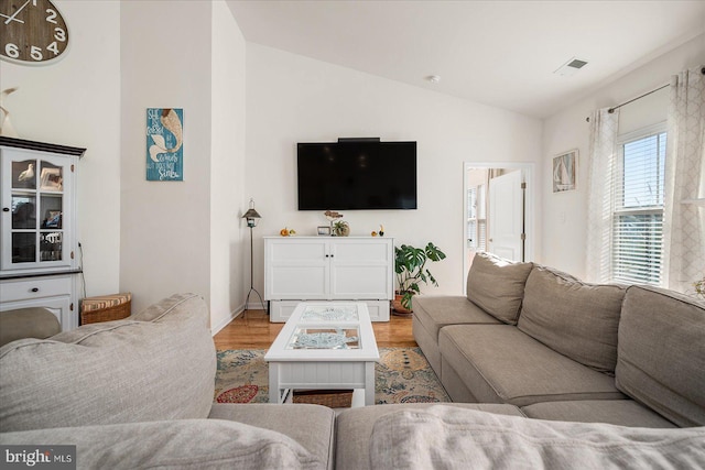 living room featuring light hardwood / wood-style floors and vaulted ceiling