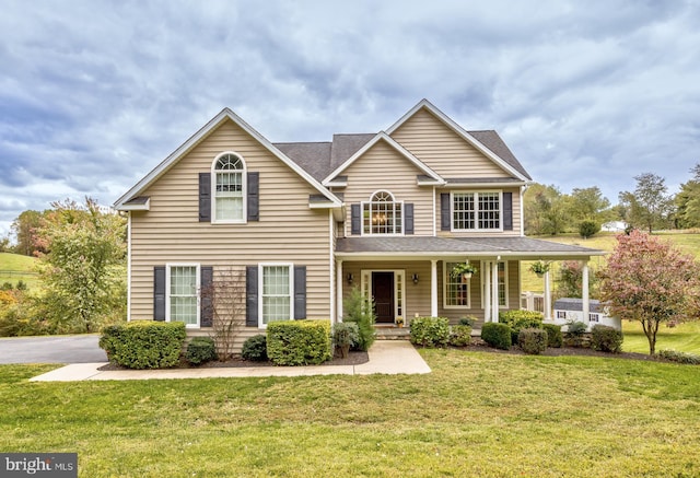 view of front of home with a porch and a front lawn