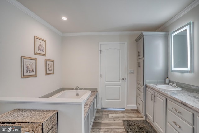 bathroom with vanity, ornamental molding, hardwood / wood-style flooring, and a bath