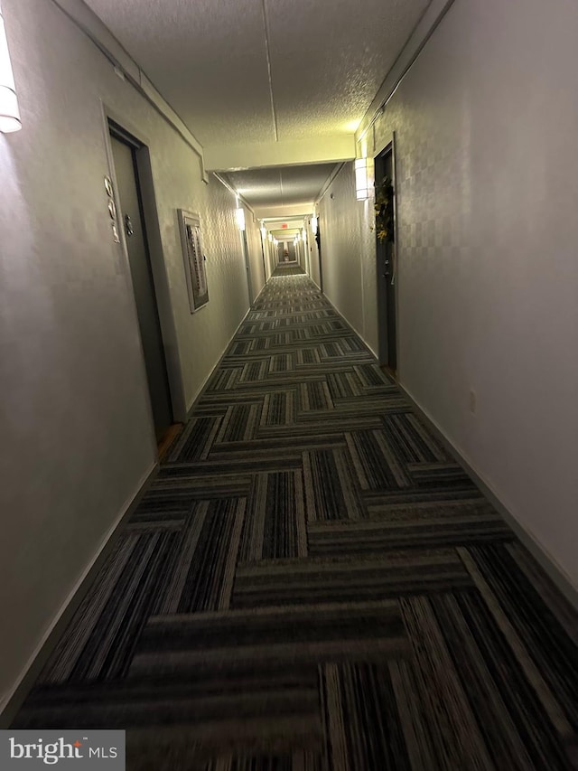 hallway with dark colored carpet