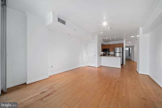 unfurnished living room featuring light hardwood / wood-style floors, crown molding, and track lighting