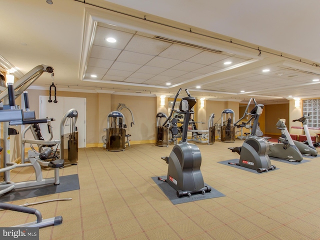 workout area with a paneled ceiling, ornamental molding, and light colored carpet