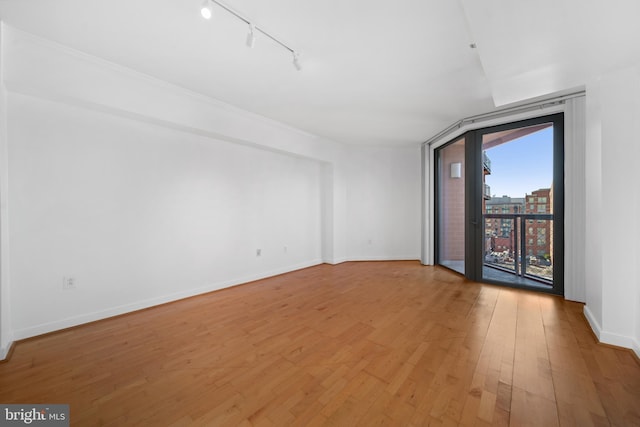 unfurnished room featuring rail lighting and light wood-type flooring