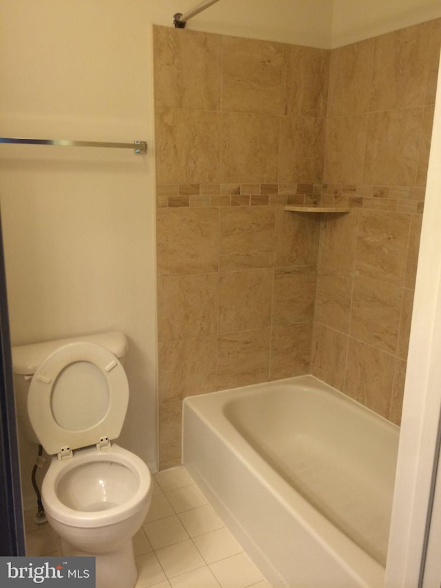 bathroom featuring tiled shower / bath combo, toilet, and tile patterned flooring