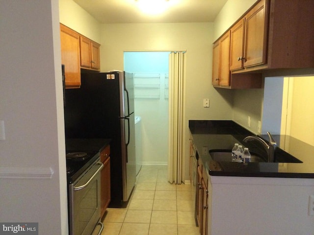 kitchen featuring sink, stainless steel stove, and light tile patterned floors