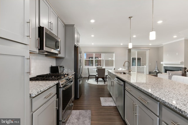 kitchen featuring gray cabinetry, sink, hanging light fixtures, stainless steel appliances, and dark wood-type flooring