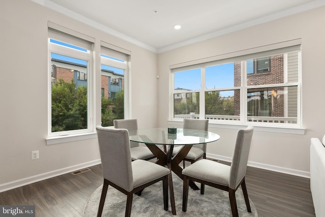 dining area with ornamental molding and dark hardwood / wood-style flooring