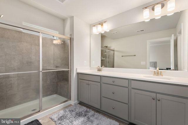 bathroom featuring a shower with door and vanity