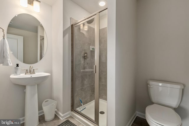 bathroom featuring tile patterned flooring, toilet, and walk in shower