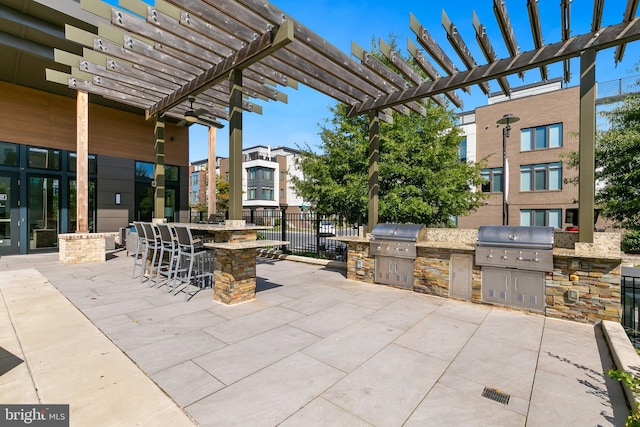 view of patio with an outdoor bar, grilling area, an outdoor kitchen, and a pergola