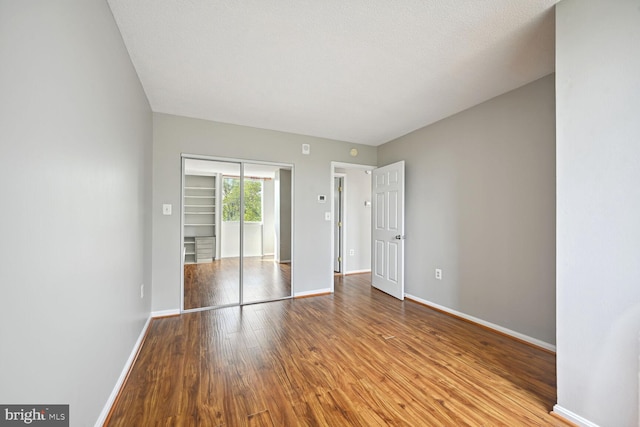 unfurnished bedroom featuring light hardwood / wood-style floors, a closet, and a textured ceiling