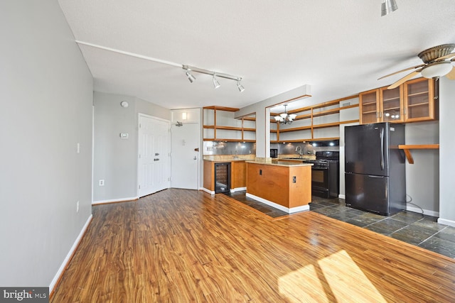 kitchen with wine cooler, black appliances, dark wood-type flooring, and a textured ceiling