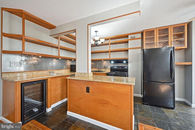 kitchen featuring wine cooler, a textured ceiling, black appliances, and sink