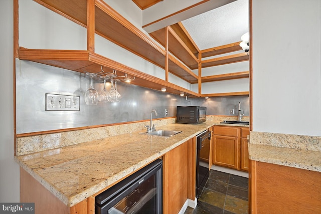 kitchen featuring light stone countertops, wine cooler, black appliances, and sink