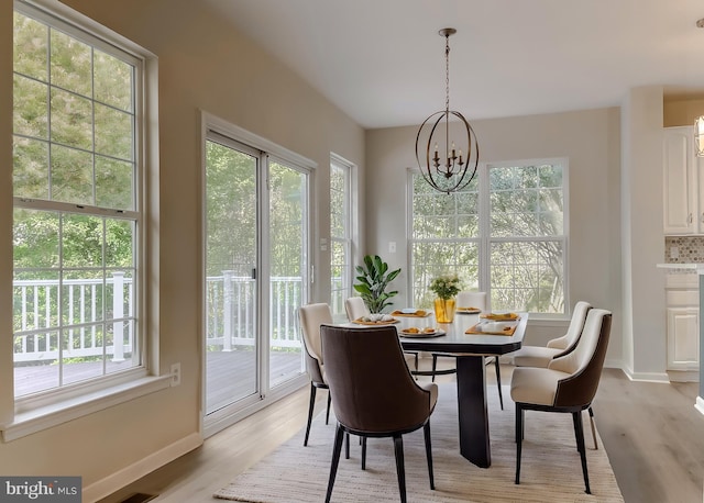 dining space with an inviting chandelier and light wood-type flooring