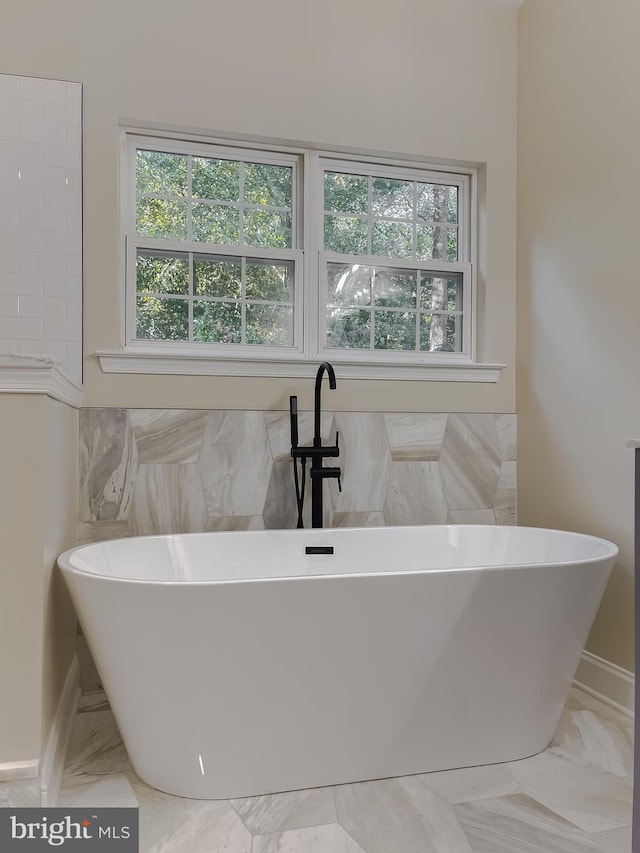 bathroom featuring a bathtub and a wealth of natural light