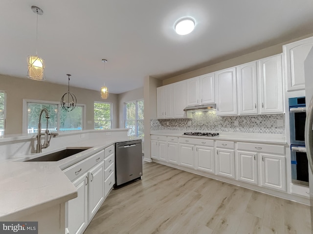 kitchen with white cabinetry, stainless steel appliances, decorative light fixtures, and light wood-type flooring