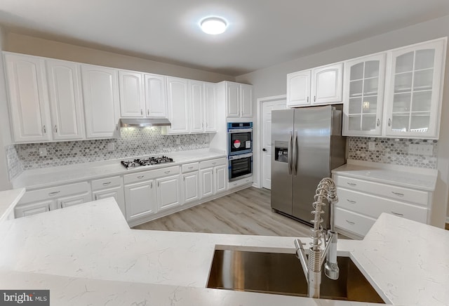 kitchen featuring white cabinetry, light hardwood / wood-style flooring, appliances with stainless steel finishes, and sink