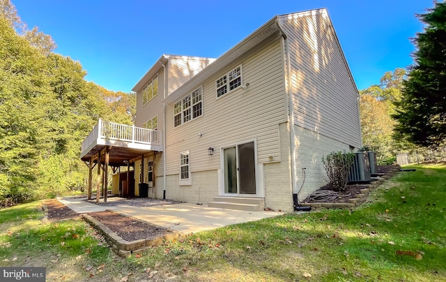 rear view of property featuring a patio, a wooden deck, and a yard