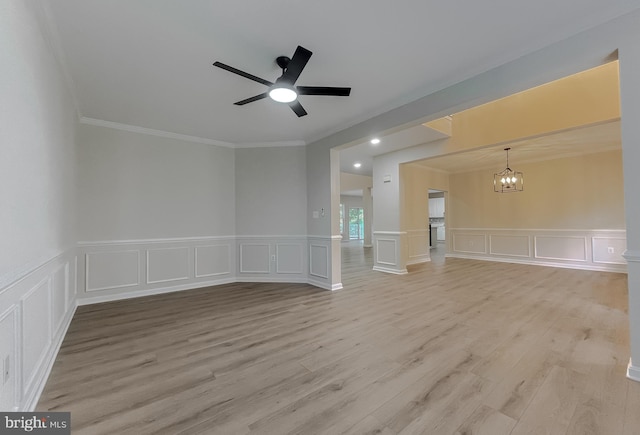 spare room featuring light hardwood / wood-style floors, ornamental molding, and ceiling fan with notable chandelier