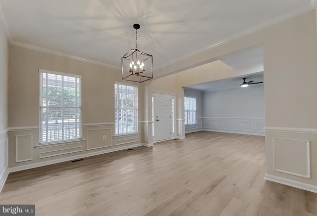 interior space featuring light hardwood / wood-style floors, ornamental molding, and a wealth of natural light