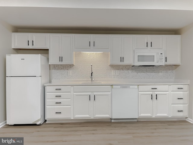 kitchen featuring light hardwood / wood-style floors, sink, backsplash, and white appliances