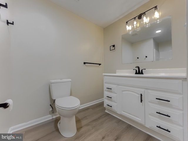 bathroom with vanity, hardwood / wood-style flooring, and toilet