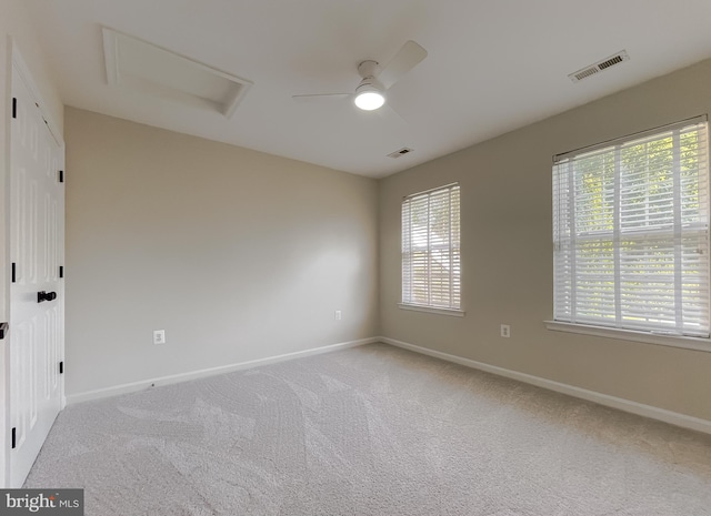 spare room featuring light carpet and ceiling fan