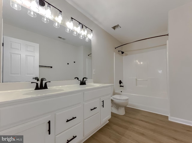 full bathroom featuring toilet, bathtub / shower combination, hardwood / wood-style flooring, and vanity